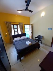 a bedroom with a bed and a ceiling fan at Madhav Mansion Beach Resort in Varkala