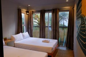 ゼネラル・ルナにあるLubihan Siargaoのベッドルーム1室(ベッド2台付)、景色を望む窓が備わります。