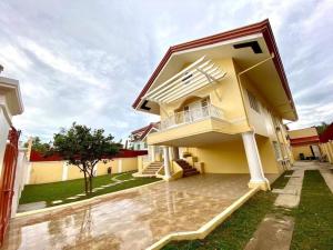 a yellow house with a balcony and a yard at Big & Elegant w/Nice Location nr SM &Ateneo Matina in Davao City