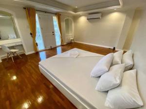 a large white bed with pillows in a room at Big & Elegant w/Nice Location nr SM &Ateneo Matina in Davao City