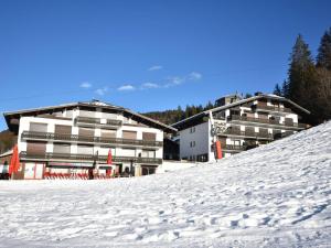 レ・ジェにあるCharmant T2 rénové, pied des pistes - 6 pers. - Centre-ville Les Gets - Balcon sud et garage - FR-1-685-29の雪に覆われた斜面にあるいくつかの建物