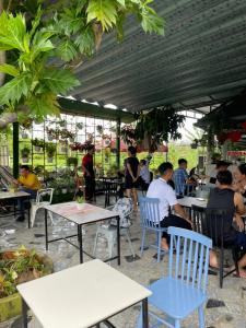 un grupo de personas sentadas en mesas en un patio en Khách sạn Hoàng Mai, en Ấp Thới Thuận (4)