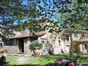 una casa de piedra con una mesa delante en Belvilla by OYO Mulino, en Cortona