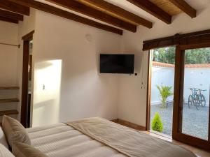 a bedroom with a bed and a television on the wall at Hotel Alandalus in Villa de Leyva