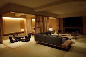ein Wohnzimmer mit einem Sofa und einem Tisch in der Unterkunft 会津東山温泉　鶴我東山総本山 in Aizu-Wakamatsu