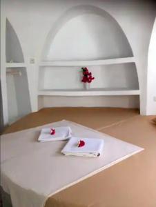 a white table with two napkins and flowers on it at Villa Dreamdome in Teluk Nara
