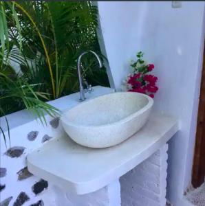 a white sink sitting on a counter with flowers at Villa Dreamdome in Teluk Nara