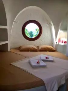 a room with a table with a round window at Villa Dreamdome in Teluk Nara