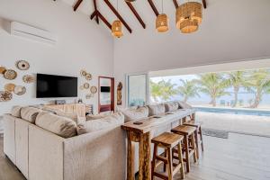 sala de estar con sofá grande y mesa en Tres Palmas Beach House, en Maya Beach