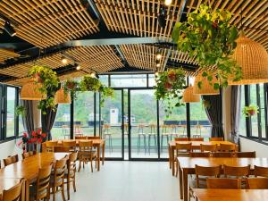 a restaurant with wooden tables and chairs and windows at Rustic house in Cat Ba