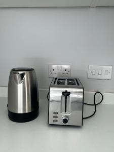 Dunstable Boutique Guest House في دانستابل: آلة تحميص الخبز وماكينة صنع القهوة على منضدة