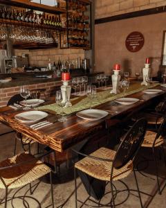 una gran mesa de madera con sillas y copas de vino en Hotel Viñedo los Arcángeles en Dolores Hidalgo