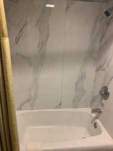 a bathroom with a white bath tub with marble walls at Executive Inn in Rusk