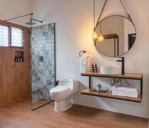a bathroom with a toilet and a shower with a mirror at Casa Medallo Hotel Boutique in Medellín +72 photos