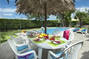 a white table with chairs and an umbrella next to a pool at Villa Tia by Villa Plus in Pollença