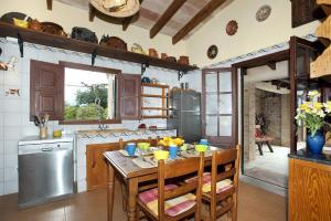 a kitchen with a wooden table with chairs and a sink at Villa Tia by Villa Plus in Pollença