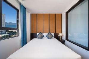 a bedroom with a bed and two windows at Se&ntilde;orita Boutique Hotel in Da Nang