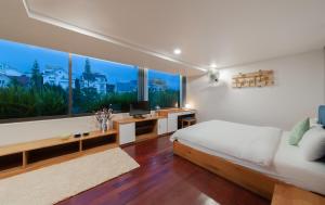 a bedroom with a bed and a large window at The K'rin Villa in Da Lat
