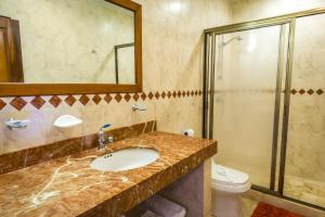 a bathroom with a sink and a shower and a toilet at Paseo del Sol Condohotel by BVR in Playa del Carmen