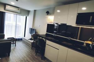 a kitchen with white cabinets and black counter tops at Dusit D2 Huahin - In the heart of Hua Hin, Walk to the beach in 6 minutes 400m, Free WiFi in Hua Hin