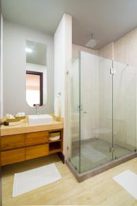a bathroom with a glass shower and a sink at Paradise Bay Hotel Boutique in Herradura