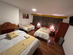 Habitación de hotel con 3 camas y 2 lámparas en Hotel Choquequirao, en Cusco