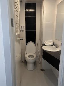 a small bathroom with a toilet and a sink at Merlin Grand Hotel in Hat Yai