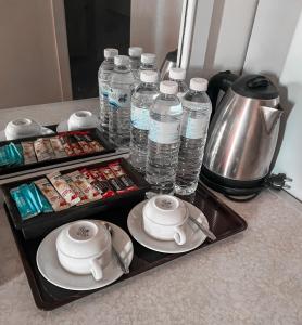 a tray with bottles of water on a counter at Merlin Grand Hotel in Hat Yai