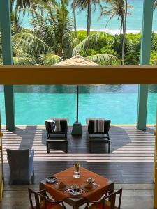 een eetkamer met een tafel en uitzicht op de oceaan bij Buckingham Place in Tangalle