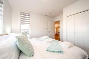 a white bedroom with two towels on a bed at Steamy Romantic Greek Corneer Suite King U/G Wifi in Edmonton +41 photos