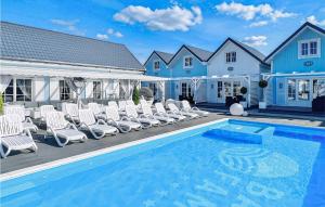 a swimming pool with chairs and a house at Stunning Home In Mielno With Wifi in Mielno