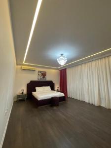 MK Resort في الدوحة: غرفة نوم بسرير وستارة حمراء