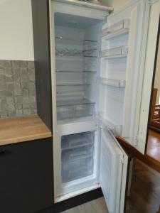 an empty refrigerator with its door open in a kitchen at Ruhige Nachbarschaft in Hamminkeln