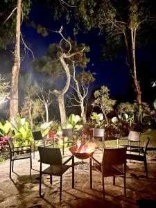 a group of chairs and a table in a garden at night at Cottonwood Exclusive Villa @Lembang Asri - Jacuzzi Playground Netflix Billyard in Lembang
