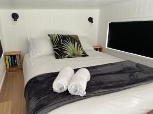 a bedroom with a bed with two towels on it at Adina Tiny House Bruny Island in South Bruny