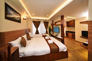 a bedroom with a large bed and a television at Capital Boutique Hotel in Kathmandu