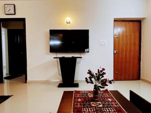 uma sala de estar com uma televisão de ecrã plano na parede em Luxurious 3BHK vacation home amidst the city. em Mangalore
