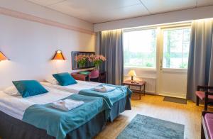 ケウルーにあるHotelli Keurusselkäのベッド2台と窓が備わるホテルルームです。