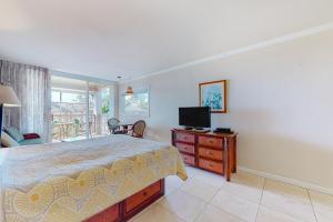 a bedroom with a bed and a television on a dresser at Islander on the Beach 304 in Kapaa