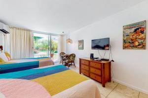 a hotel room with two beds and a television at Islander on the Beach 170 in Kapaa