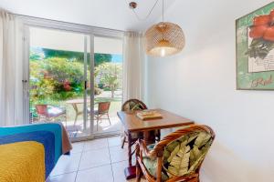 a bedroom with a table and chairs and a window at Islander on the Beach 170 in Kapaa