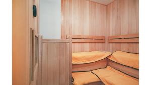 Kuretake Inn Premium Shizuoka Annex في شيزوكا: سريرين بطابقين في غرفة مع جدران خشبية