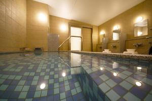 Kuretake Inn Premium Shizuoka Annex في شيزوكا: حمام فيه مسبح مغسلتين ومرايا