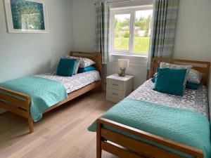 a bedroom with two beds and a window at Westerley Country B & B with exclusive Guest lounge in Buckfastleigh