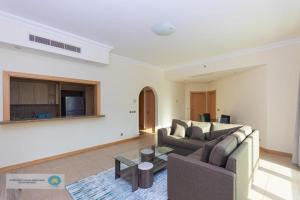 a living room with two couches and a table at Palm Jumeirah Dubai 2 Bed in Dubai