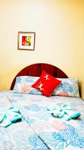 a bed with two red pillows on top of it at Heart Hotel and Services in Dumaguete
