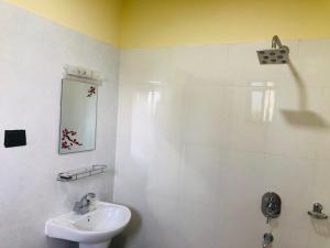 a white bathroom with a sink and a shower at Hotel Happy Land in Chitwan