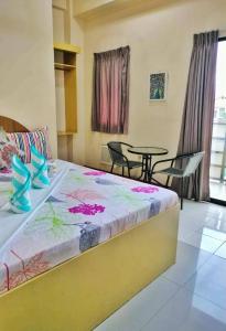 a bedroom with a bed with a table and chairs at Heart Hotel and Services in Dumaguete