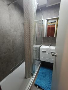 La salle de bains est pourvue d'une baignoire, d'un lavabo et d'une douche. dans l'établissement auris en oisans, vue sur le massif des ecrins, à Auris