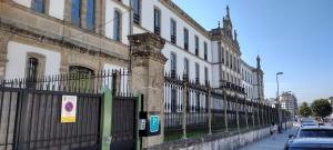 una recinzione in ferro battuto di fronte a un edificio di Hospedería San Froilan a Lugo